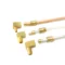 Brass and metal pipe fittings with attached tubes arranged on a white